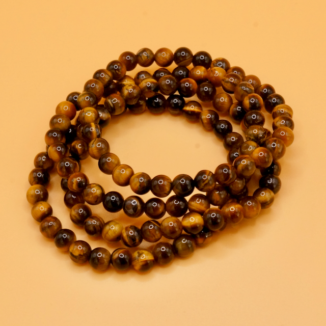 flexibles Armband aus Tigeraugen Perlen, die goldig, seidig schimmernd glänzen. Tigerauge gilt als Schutzstein, der gerne für Harmonie auch bei Meditationen auf das Solar Plexus Chakra aufgelegt wird.